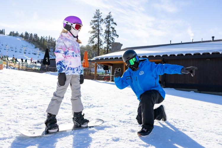 An instructor guides a student on a snowboard at Snow Summit ski resort in Big Bear Lake, CA.