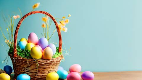 Stock photo: An Easter basket sits on a table with colorful eggs and yellow flowers. The background wall is turquoise.