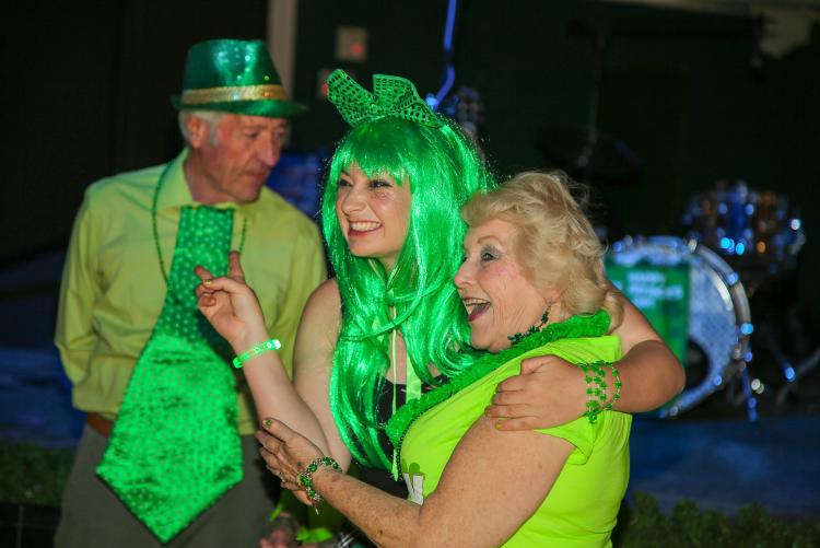 Two females posing for a photo during the St. Patrick's Day at Wyatt's Grill & Saloon, they are wearing vivid green costumes.