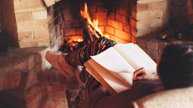 Woman reads by the fire